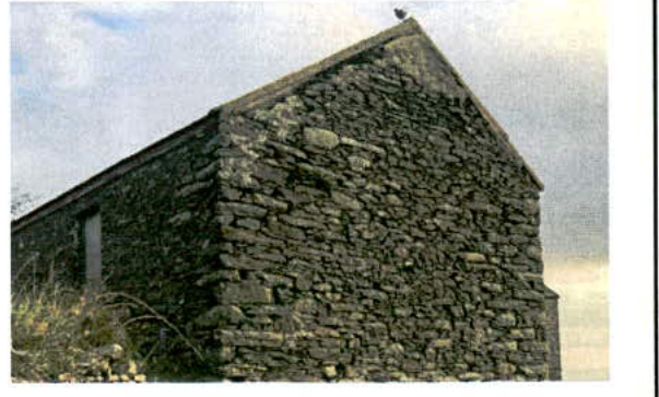 A photograph showing the exterior of a traditional stone building with a pitched roof, likely an existing barn or outbuilding.