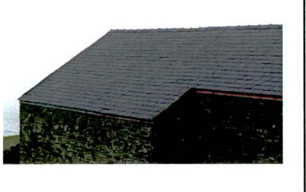A close-up photograph showing the slate roof and rough stone wall of a building, likely an existing structure on the site.