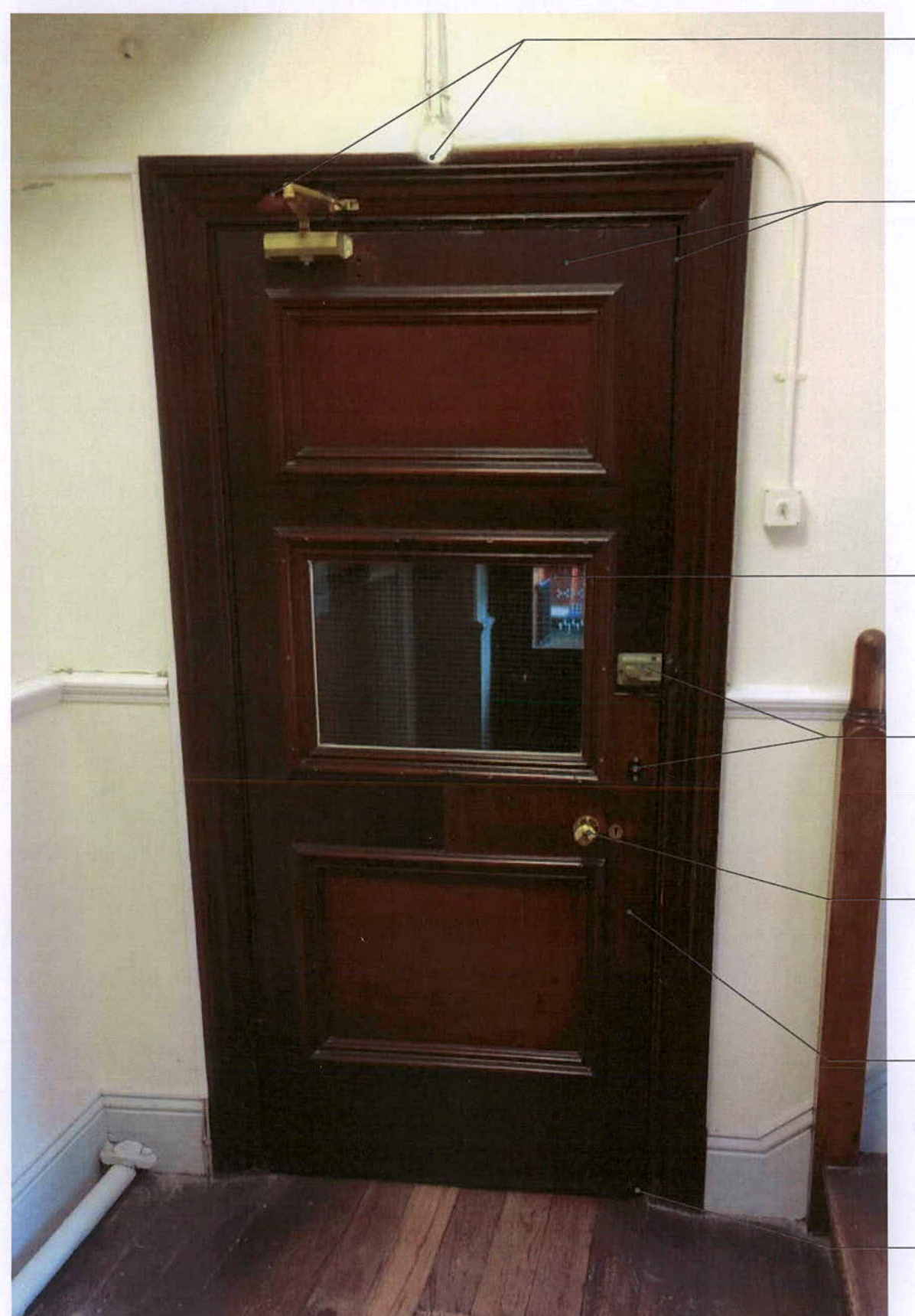 Annotated photograph of a dark wooden internal door with glass panels and brass hardware, showing details relevant to building consent.