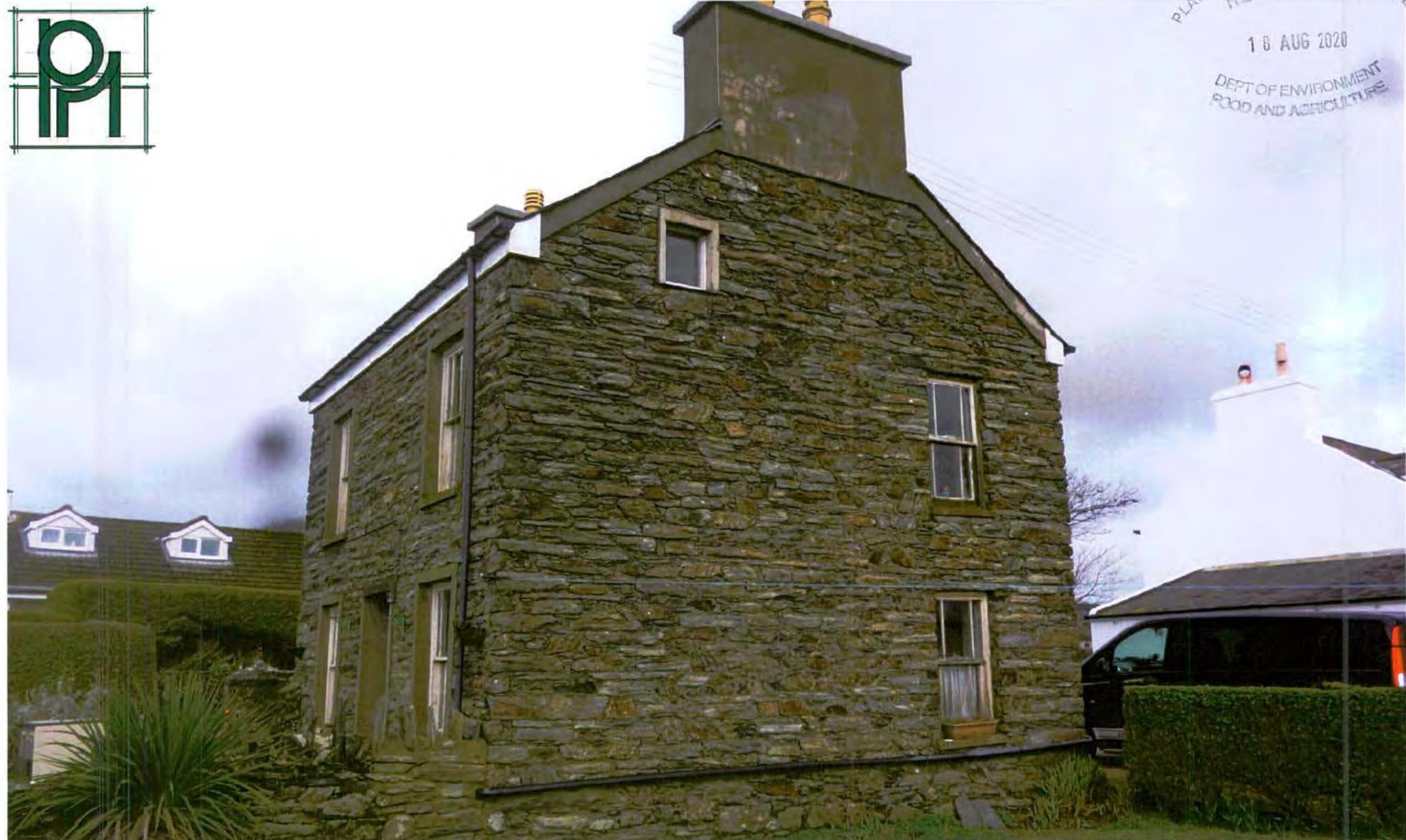 A photograph showing the exterior of a two-story stone house with a pitched roof and chimneys, likely the existing property for the planning application.