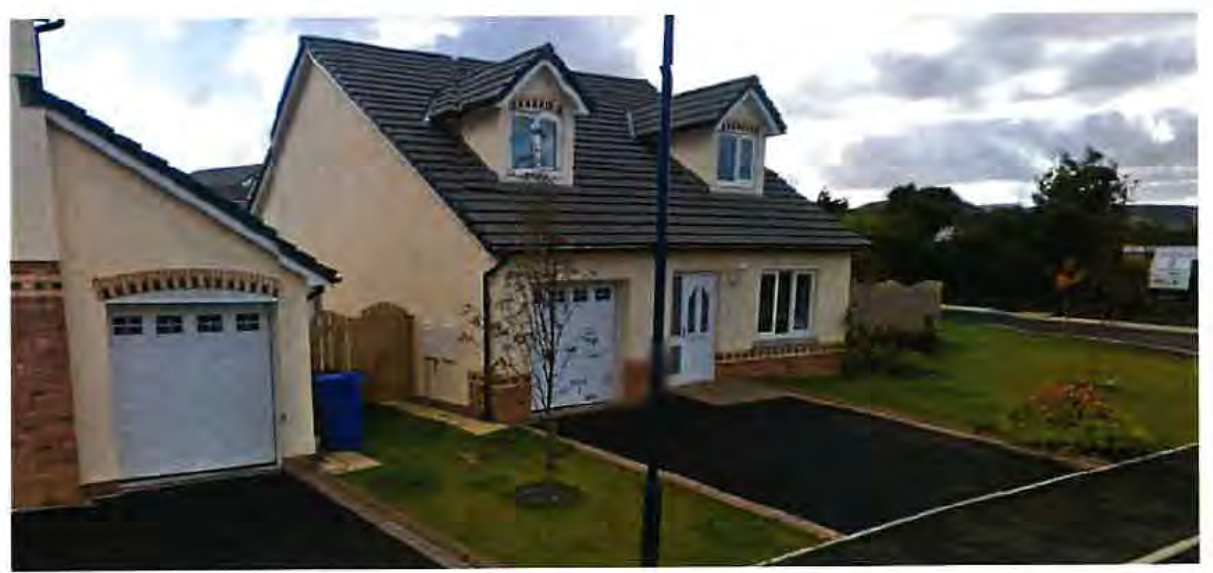 A photograph showing a detached bungalow with a pitched roof featuring two dormer windows and an attached single garage. The property includes a paved driveway, a small front lawn, and is situated in a residential area.
