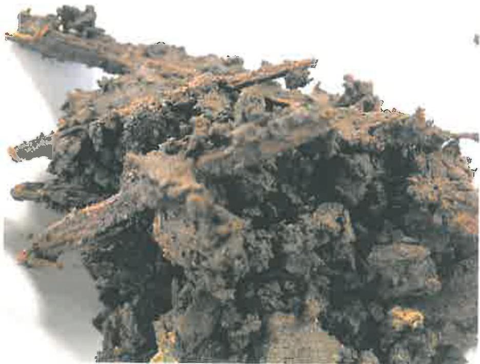 A highly pixelated and distorted image that appears to be a low-quality photograph of a rocky or rough terrain, possibly a coastal or rural site.