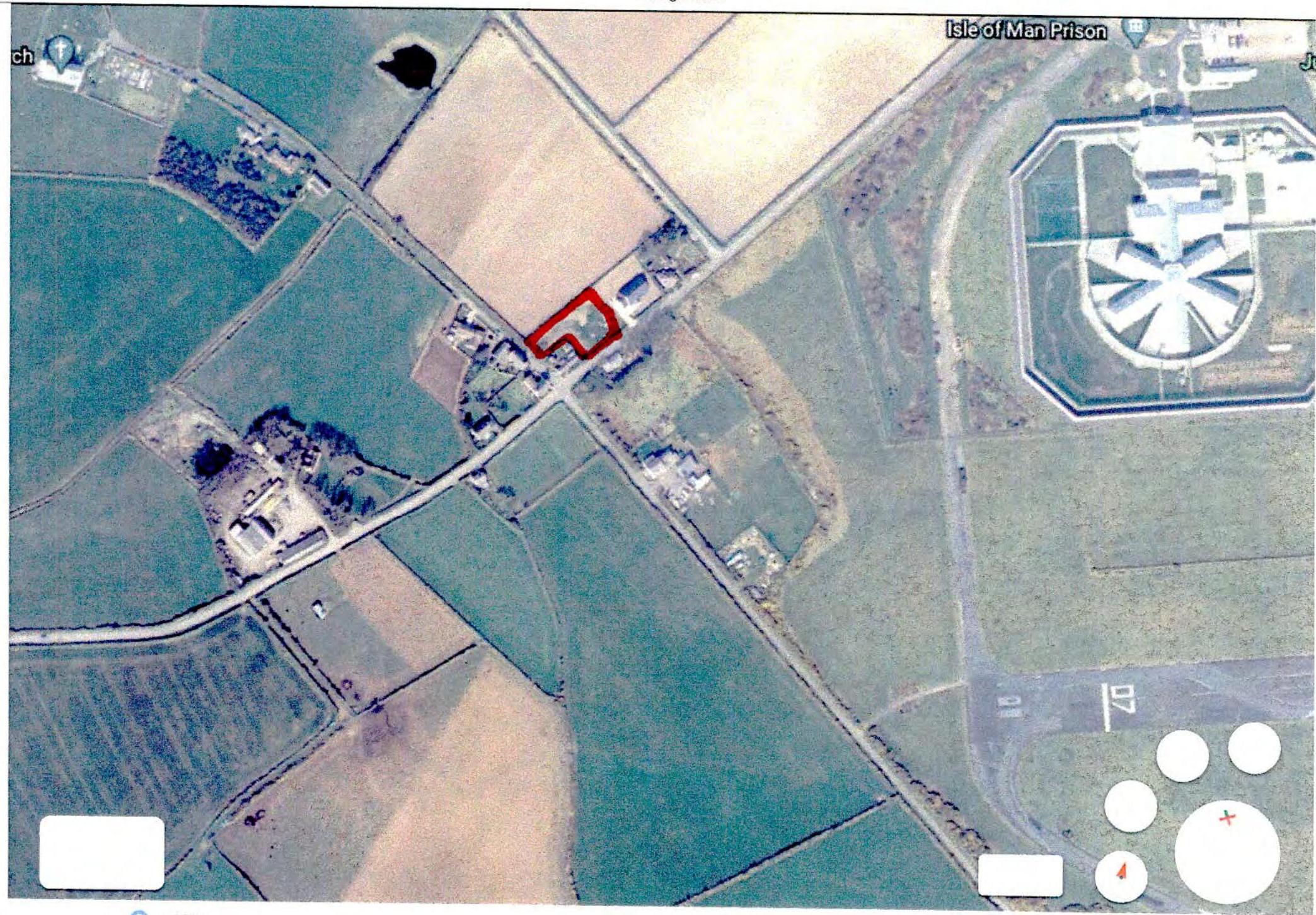 An aerial site location map highlighting a specific plot of land with a red outline in a rural setting near the Isle of Man Prison.