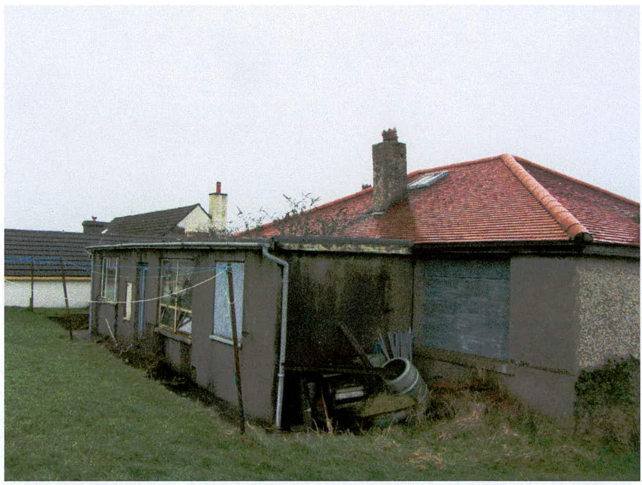 Exterior photograph of an existing single-story detached bungalow with an attached garage and red tiled roof.