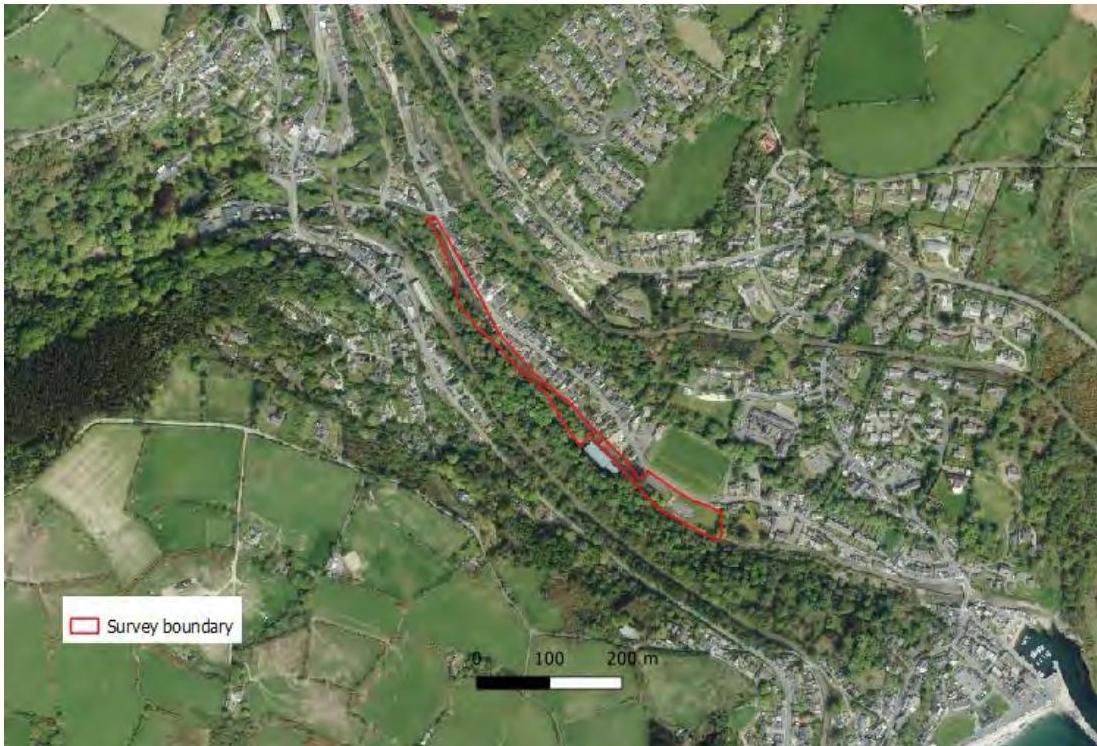 An aerial map view showing a red survey boundary line overlaid on a residential and green landscape with a scale bar.
