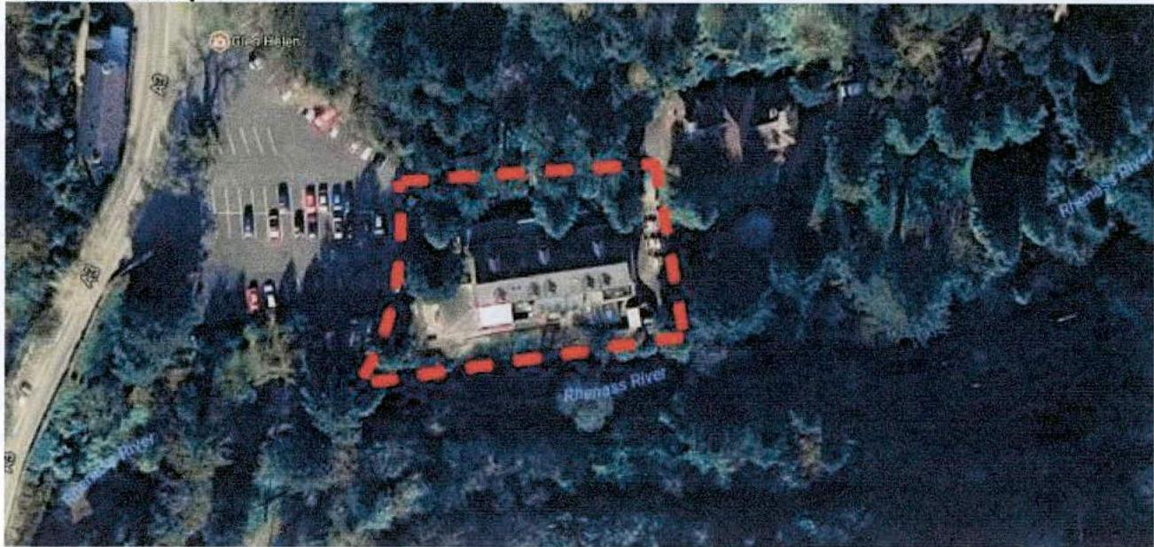 An aerial site location map showing a building outlined in red dashed lines within a wooded area, adjacent to a parking lot and the Rhenass River.