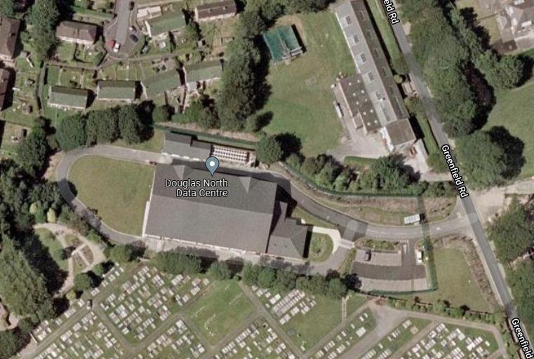 An aerial satellite view showing the Douglas North Data Centre site, including the main building, surrounding roads, and an adjacent cemetery.