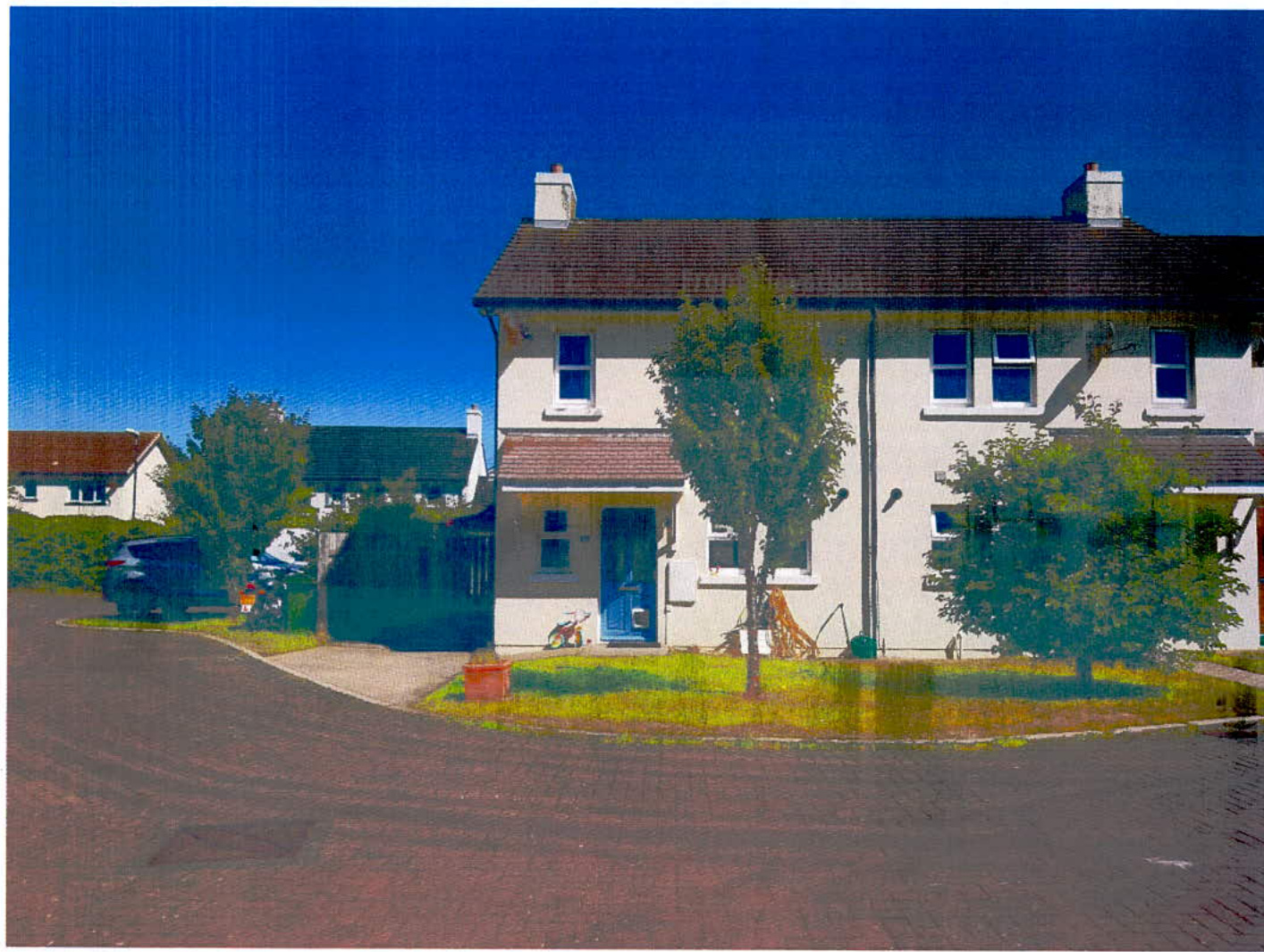 A photograph showing the existing white two-story semi-detached house with a blue front door, front garden, and driveway.