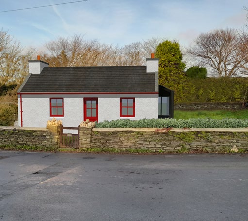 A photograph of a white single-story bungalow with red window frames and a dark roof, featuring a modern dark extension on the right side situated behind a stone wall.