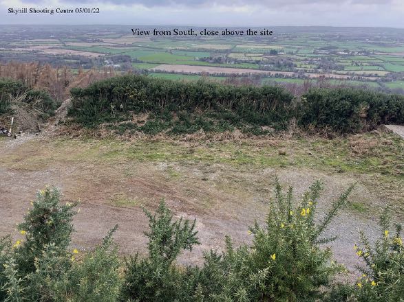 A photograph showing a rural landscape view from the south, looking over fields and hedgerows towards the proposed site location.