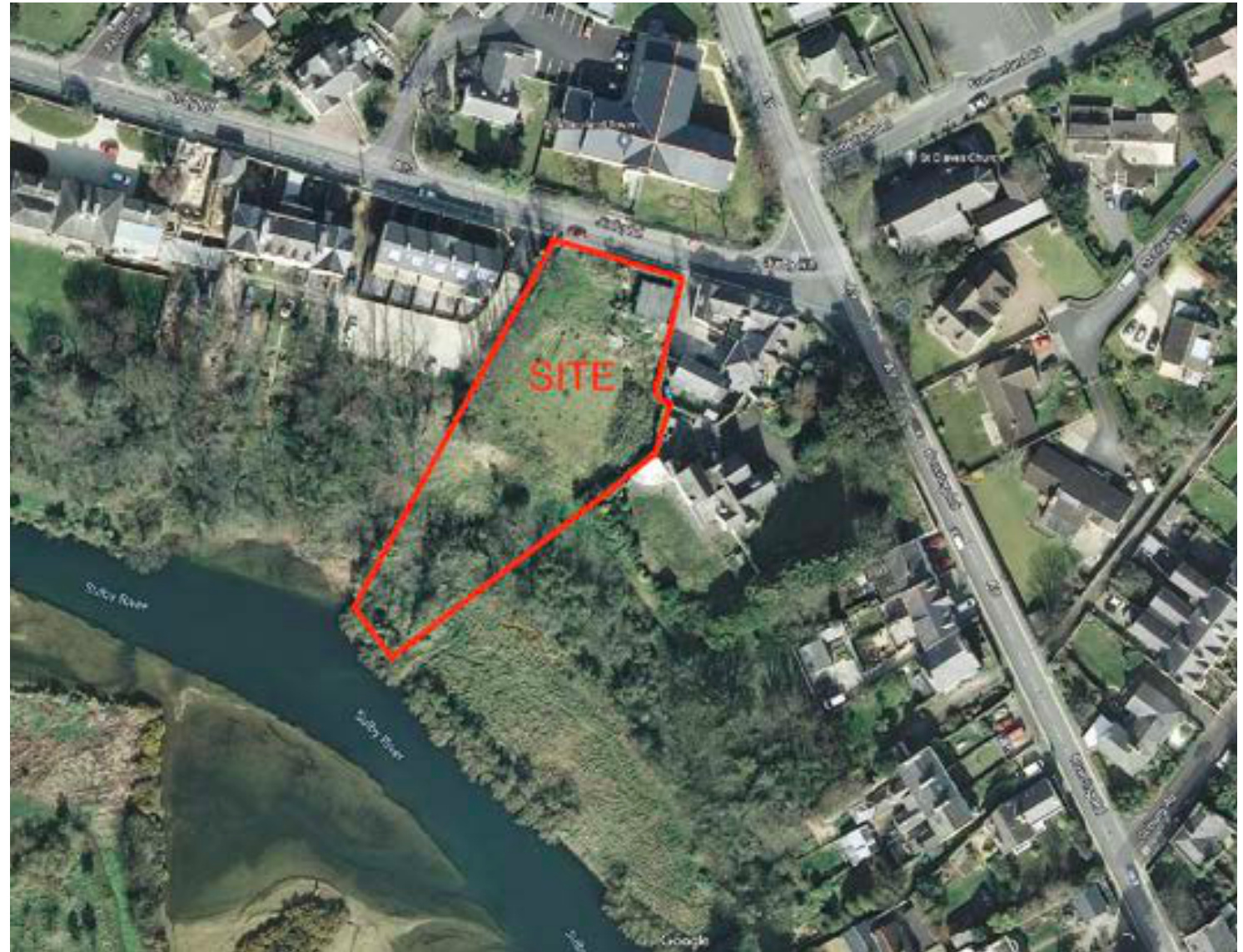 An aerial site location map showing a plot of land outlined in red labeled 'SITE' situated next to the Sulby River and near a road junction.