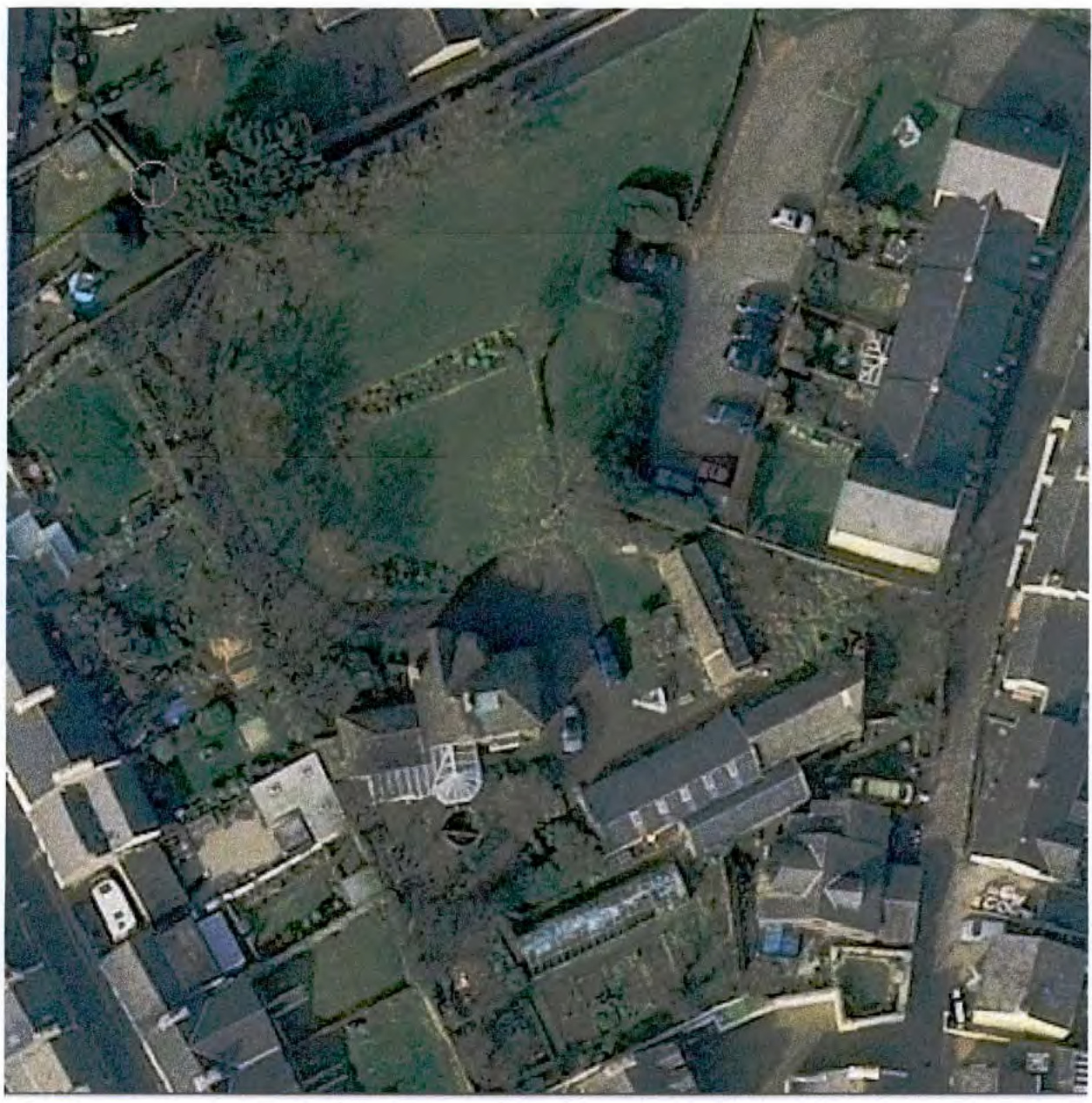 An aerial photograph showing a residential property with a large garden, driveway, and surrounding neighboring houses and fields.