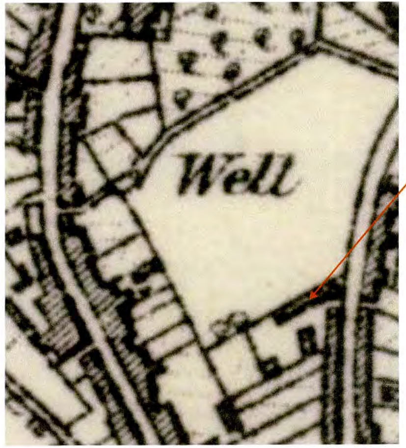A black and white historical map extract showing field boundaries and a feature labeled 'Well', with a red arrow indicating a specific site location.