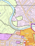 A planning map displaying color-coded land use zones, a winding watercourse, and street layouts.