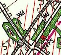 A close-up section of a site plan showing green shaded areas, road lines, and red boundary markings.