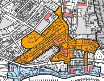 A hand-drawn site plan map highlighting a specific area in orange, showing surrounding streets and a coastal boundary at the bottom.