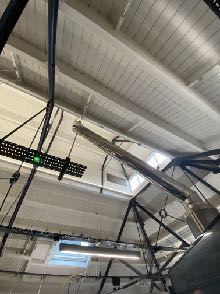 Interior photograph looking up at exposed ceiling beams, ductwork, and wiring during renovation works.