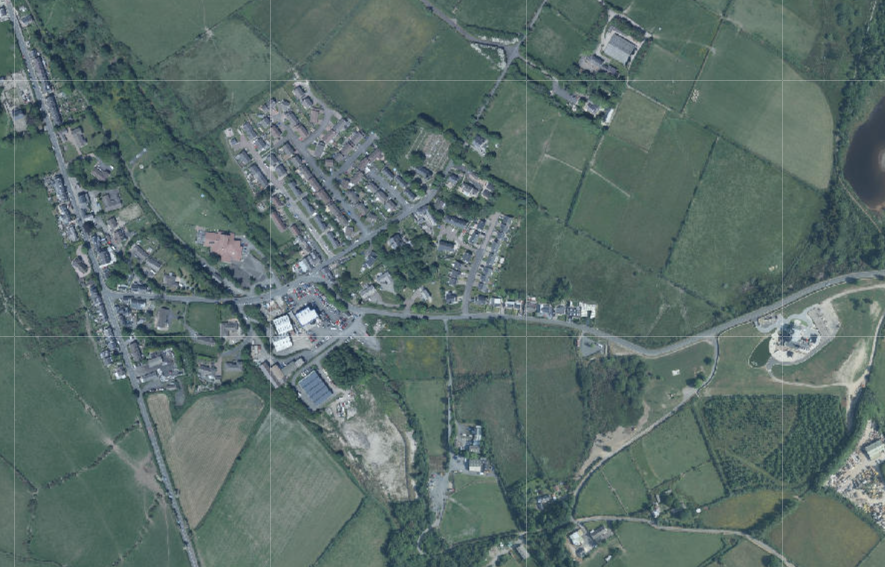 Aerial map view showing a rural settlement surrounded by agricultural fields and roads with grid overlays.