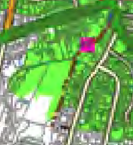 A low-resolution digital map showing a green rural landscape with roads and a highlighted pink plot area.