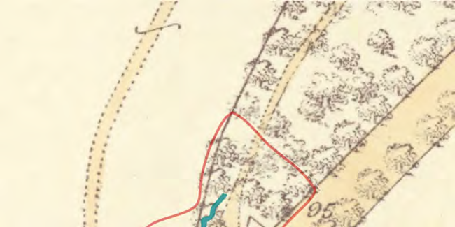 A vintage topographical map extract showing a plot of land outlined in red, featuring trees, paths, and a small water feature.