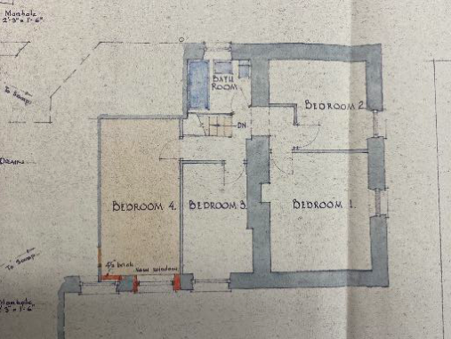 The image displays a hand-drawn architectural floor plan showing the layout of a proposed dwelling with four bedrooms and a bathroom.