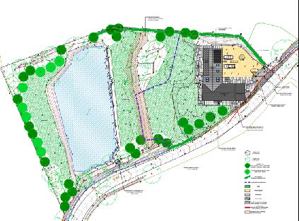 A detailed site plan illustrating a property layout featuring a large lake, a building footprint, and surrounding landscaping with trees.