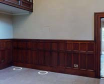 Interior photograph showing a room with dark wood wainscoting and a mezzanine level, consistent with listed building restoration works.