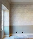 Interior photograph of a room featuring a window and two-tone painted walls, likely documenting restoration works.