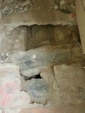 A close-up photograph showing a rough, excavated section in a stone wall, likely during renovation or construction work.