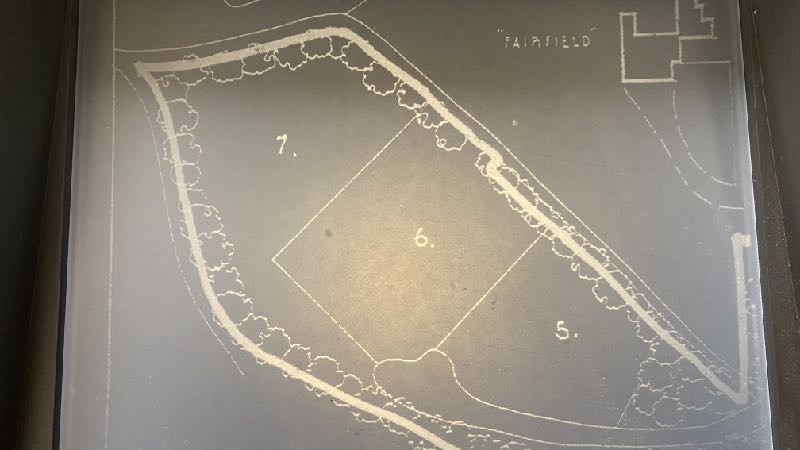 A site plan showing plot boundaries numbered 5, 6, and 7 with tree symbols along the perimeter and a label 'FAIRFIELD'.