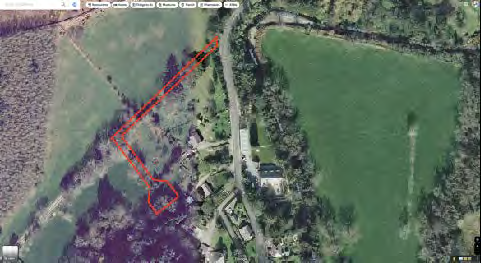 Aerial satellite map view showing a red outlined boundary around a building and land in a rural setting.