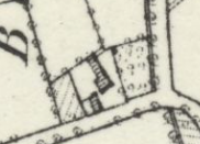 A black and white site plan or map extract showing property boundaries, hatched building footprints, and vegetation markers.
