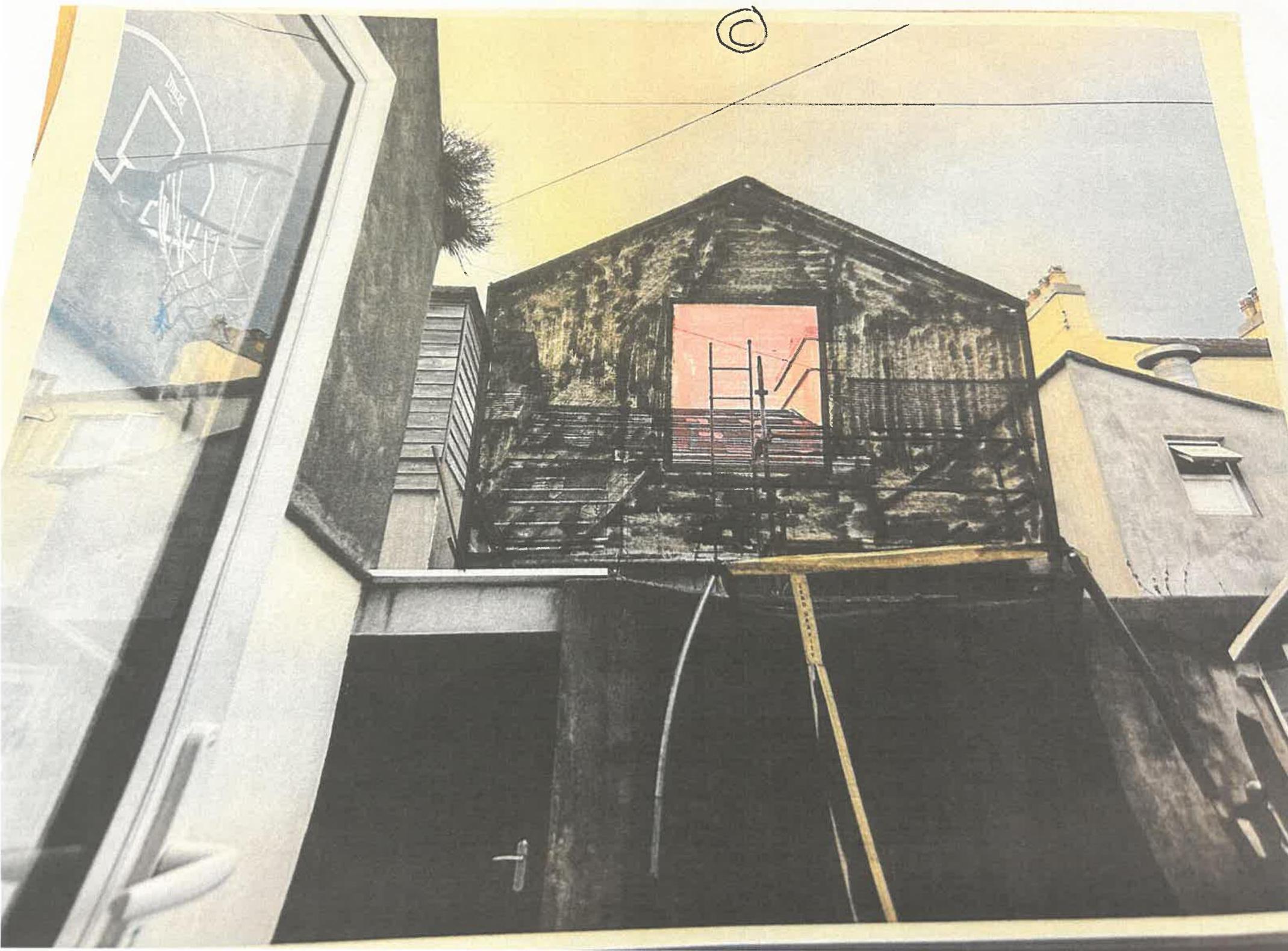 A low-angle photograph showing a timber-framed first-floor extension under construction with scaffolding visible against the sky.