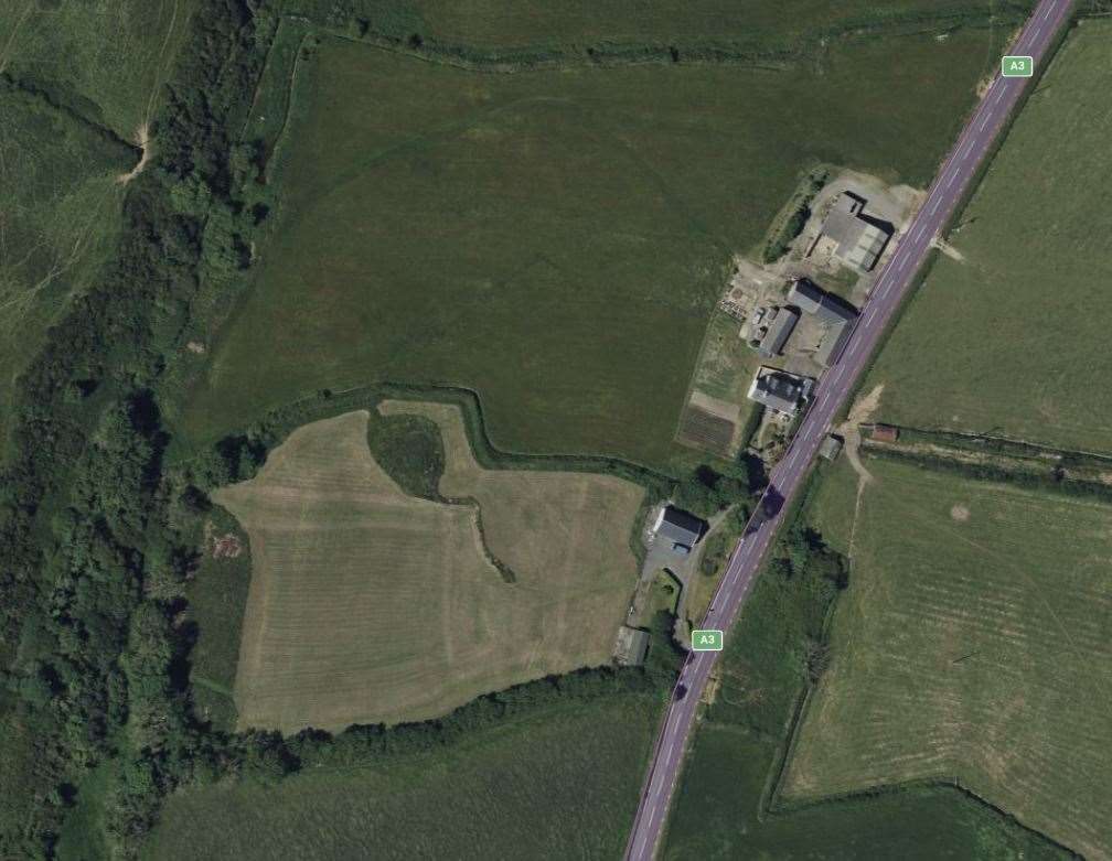 Aerial satellite view of a rural site showing the A3 road and surrounding agricultural fields.