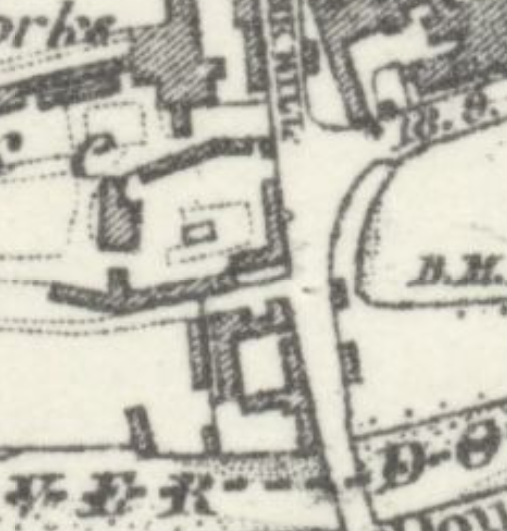 A close-up view of a historical black and white map showing building footprints, property boundaries, and road layouts.
