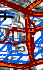 A low-resolution, abstract view of a planning map or site plan showing thick red and blue lines overlaid on a grey background.