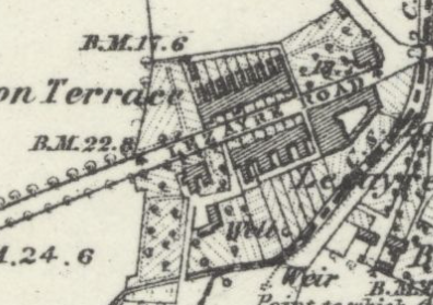 A close-up view of a historical site plan or OS map showing building footprints, a road, and boundary markers.