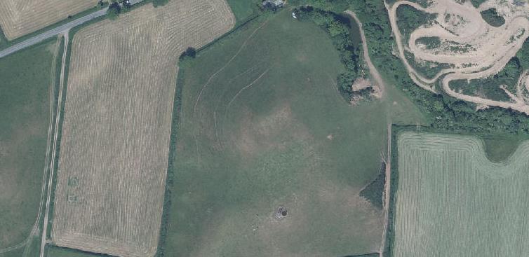 An aerial satellite view of a rural agricultural site showing fields, tracks, and a small central feature, likely serving as a location map for the planning application.