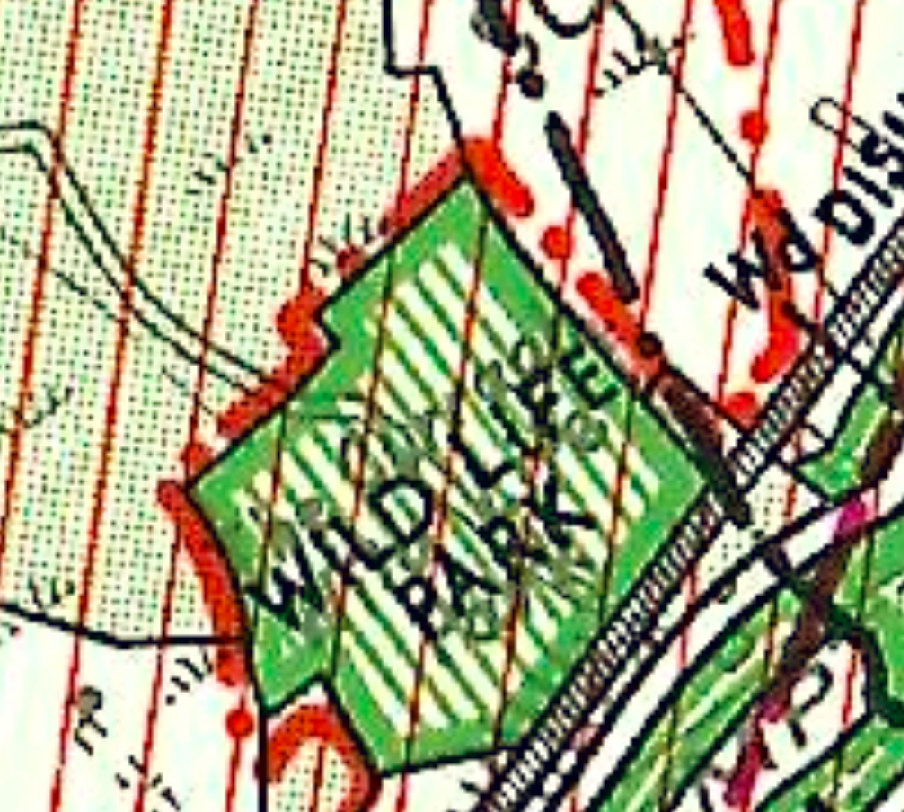 A close-up section of a topographical map showing a green shaded area labeled 'WILD LIFE PARK' with red grid lines and boundary markers.