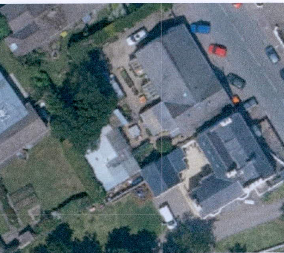 Aerial satellite view of a residential property showing the main house, garden, and neighboring buildings.