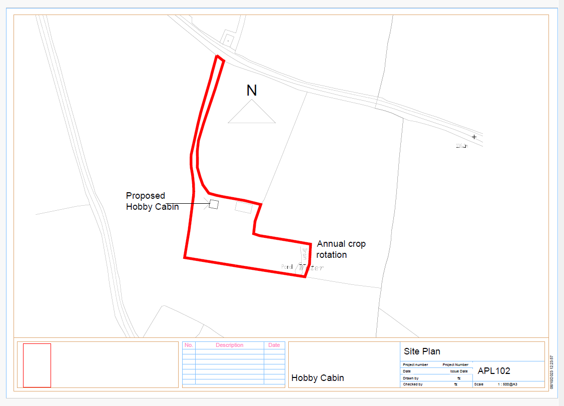 A site plan showing the red-outlined boundary of a plot of land with a proposed hobby cabin location marked.