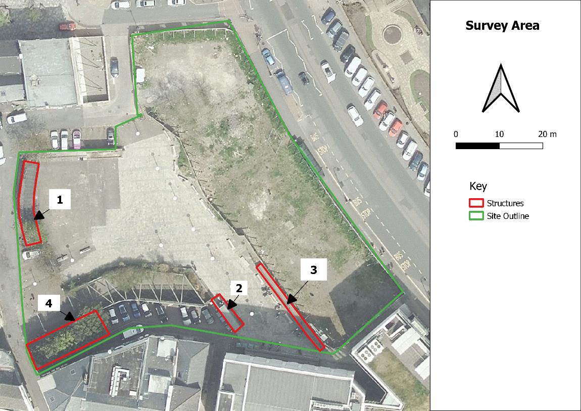 An aerial site survey map showing a paved area with parking, marked with green site boundaries and red structure outlines.