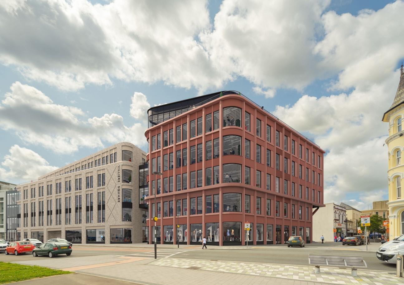 A street-level view of the modern Villiers Square development in Douglas, featuring a prominent reddish-brown multi-story commercial building with curved corners and ground-floor retail, adjacent to a lighter stone bu...