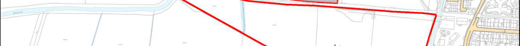 A site plan showing a large plot of land outlined in red, adjacent to a watercourse and existing residential areas.