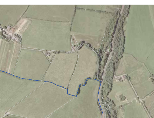 Aerial site plan showing the proposed development site boundaries outlined in white lines within a rural landscape of fields and hedgerows.