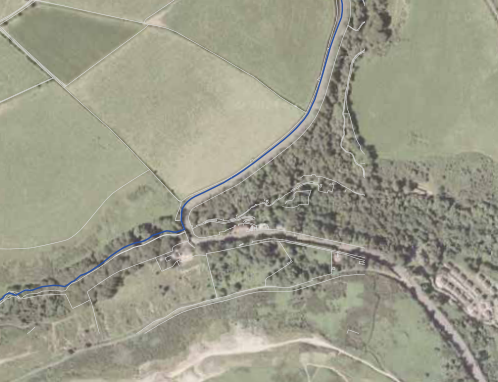 An aerial site plan showing the property boundaries overlaid on a rural landscape with fields and trees.