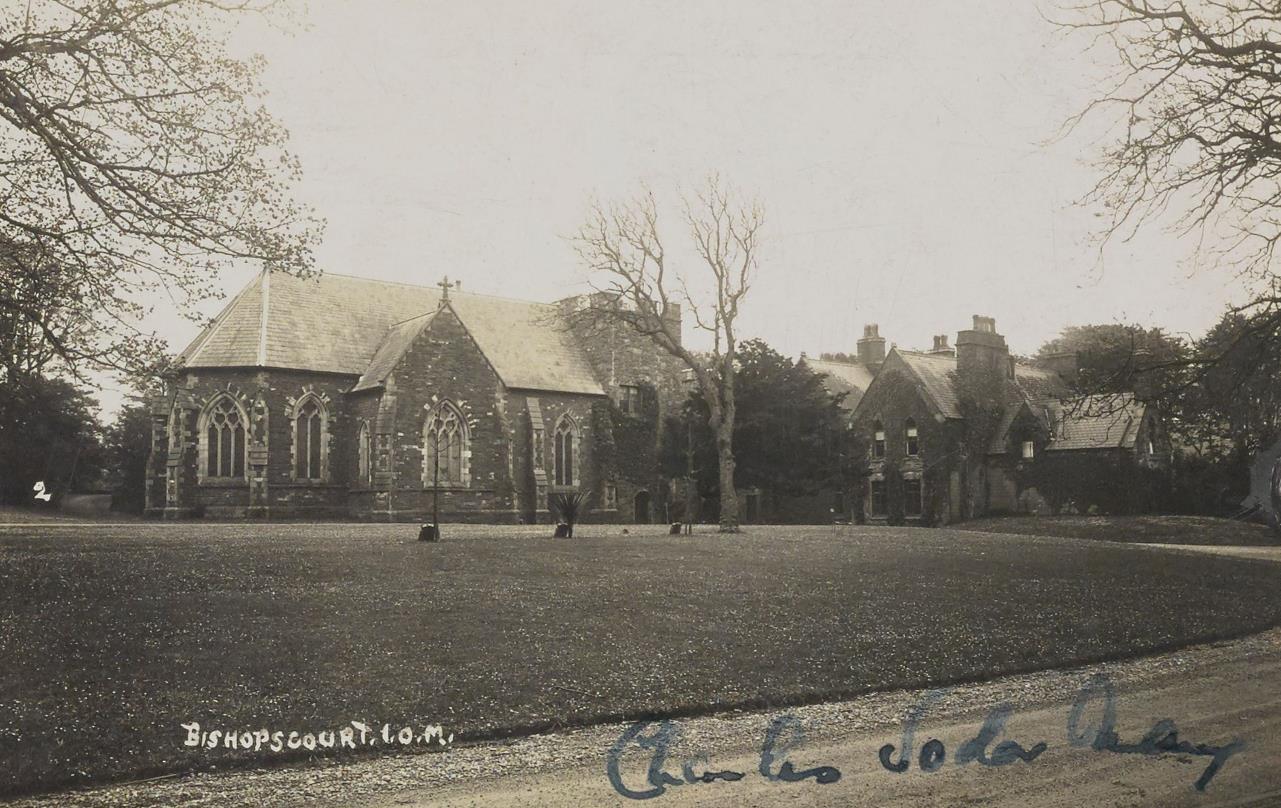 A vintage sepia-toned photograph of Bishopscourt in the Isle of Man, depicting a stone chapel and an adjacent residential building.