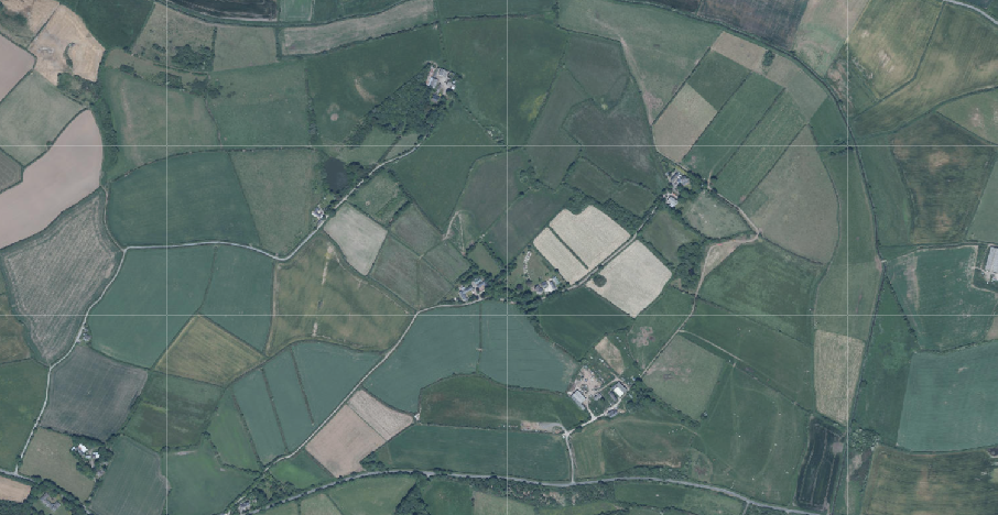 Aerial view of a rural landscape showing agricultural fields and hedgerows, likely a site location map with a grid overlay.