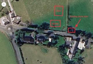 An aerial view of a rural property with red boxes outlining specific buildings and land areas, including a label for an existing stone barn.