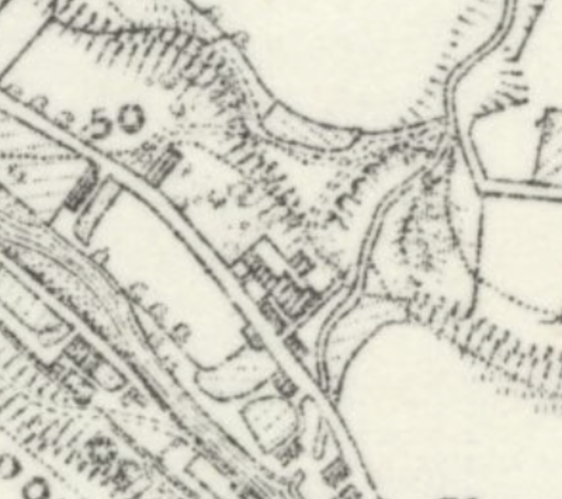 The image displays a close-up section of a vintage black and white topographical map, likely an Ordnance Survey map. It shows road networks, building footprints, and vegetation symbols typical of a site location plan.
